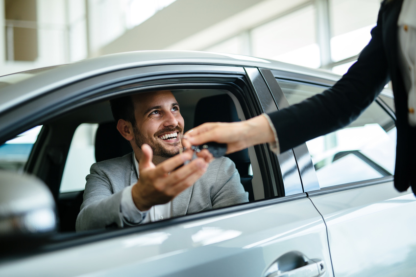 Portrait of happy young customer buying new car